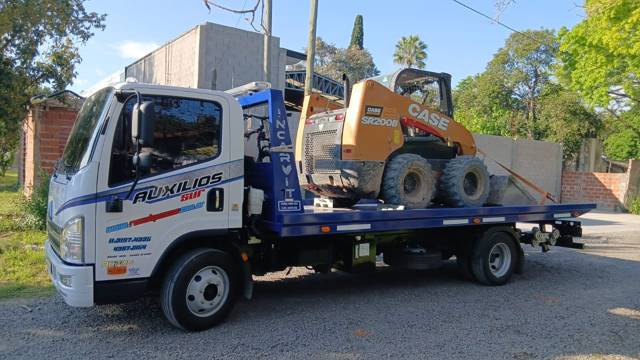 Minicargadora en camión plancha